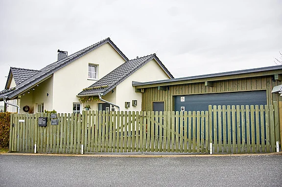 Schlüsselfertiger Neubau eines Einfamilienhauses in Walddorf mit Zufahrt und Holzzaun